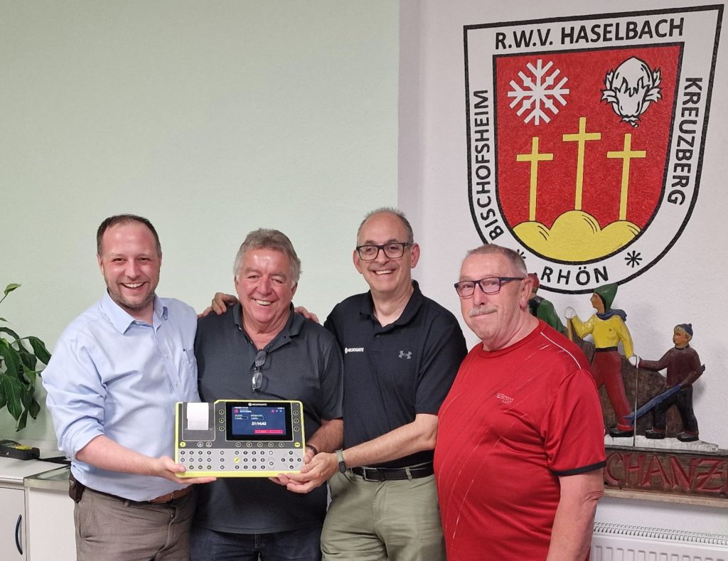 Vier Männer lächelnd mit dem neuen ReiPro-Zeitmesssystem in der Hand.