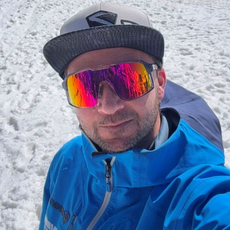 Porträtbild in Skijacke vor Bergen im Schnee
