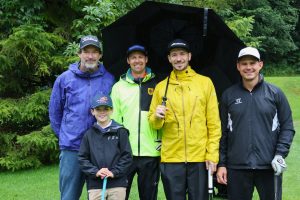 Felix Neureuther mit seinem Team auf einem Golfplatz.