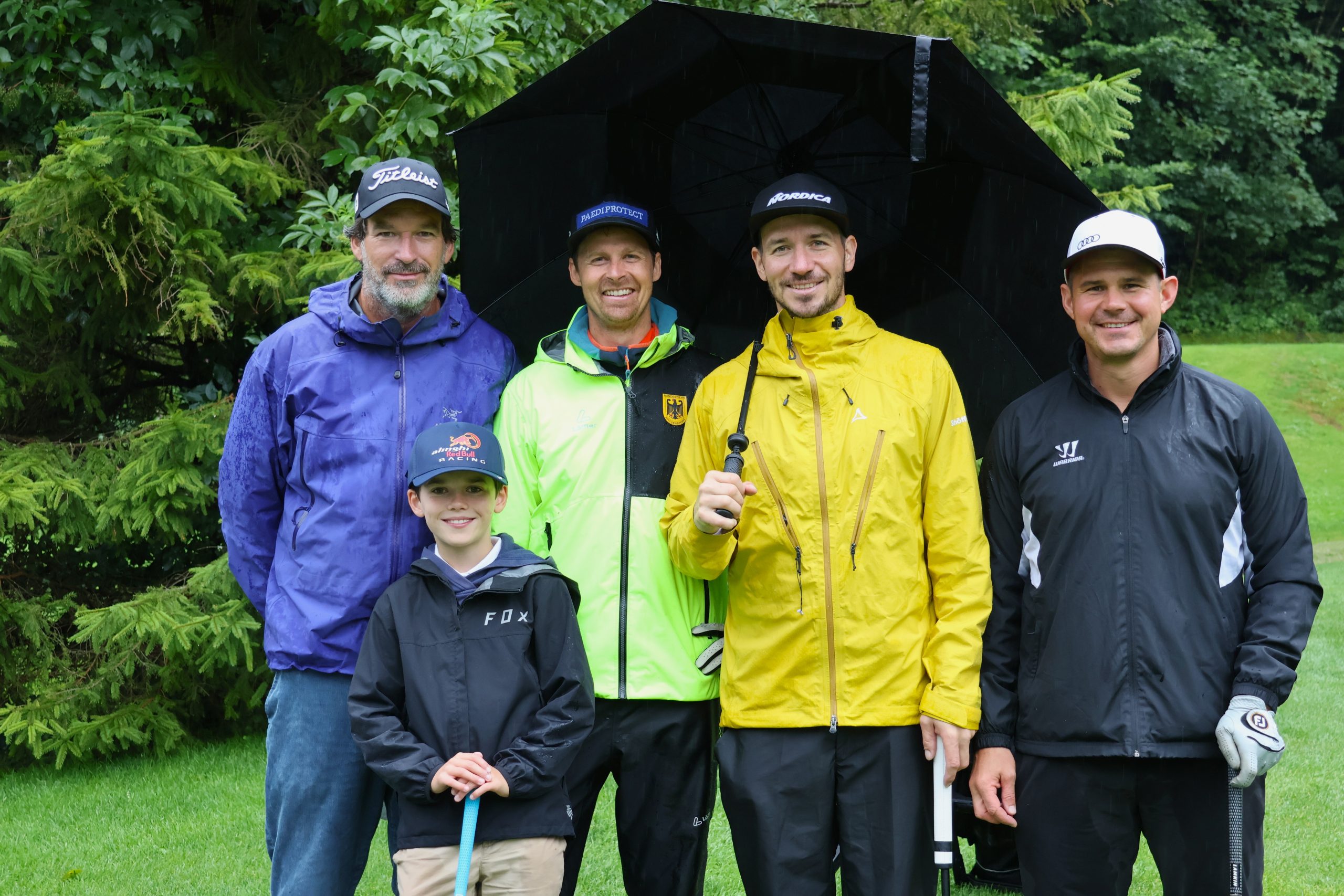 Felix Neureuther mit seinem Team auf einem Golfplatz.
