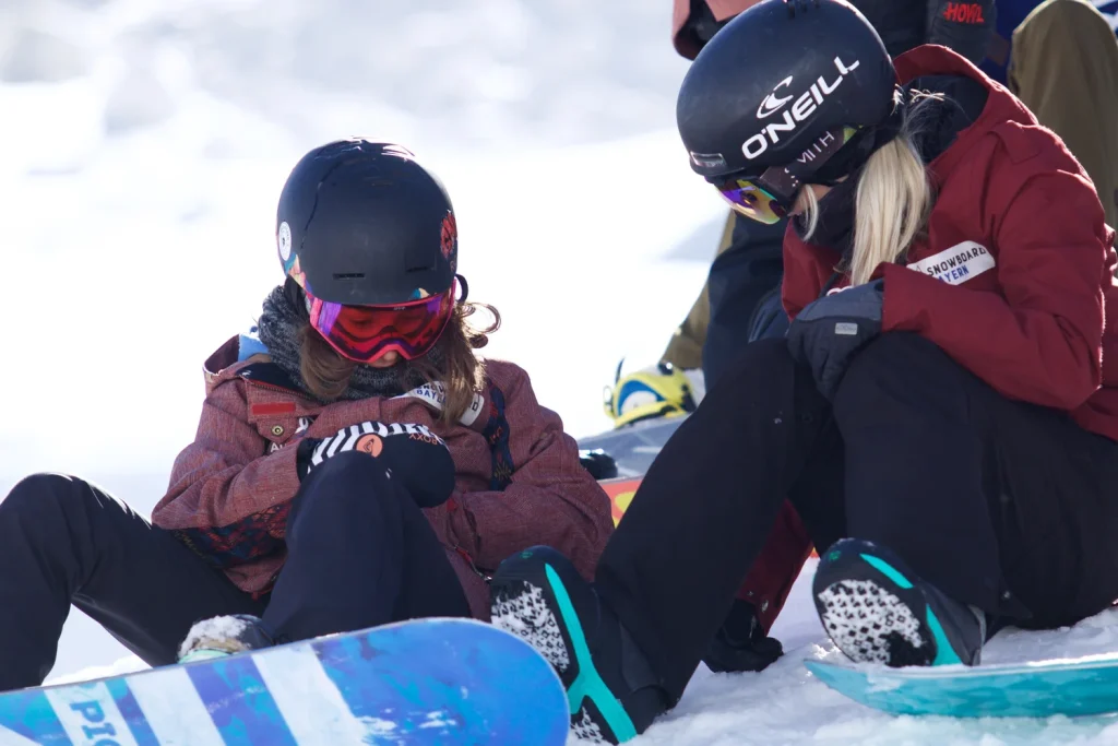 snowboarderin mit coach sitzen am Boden