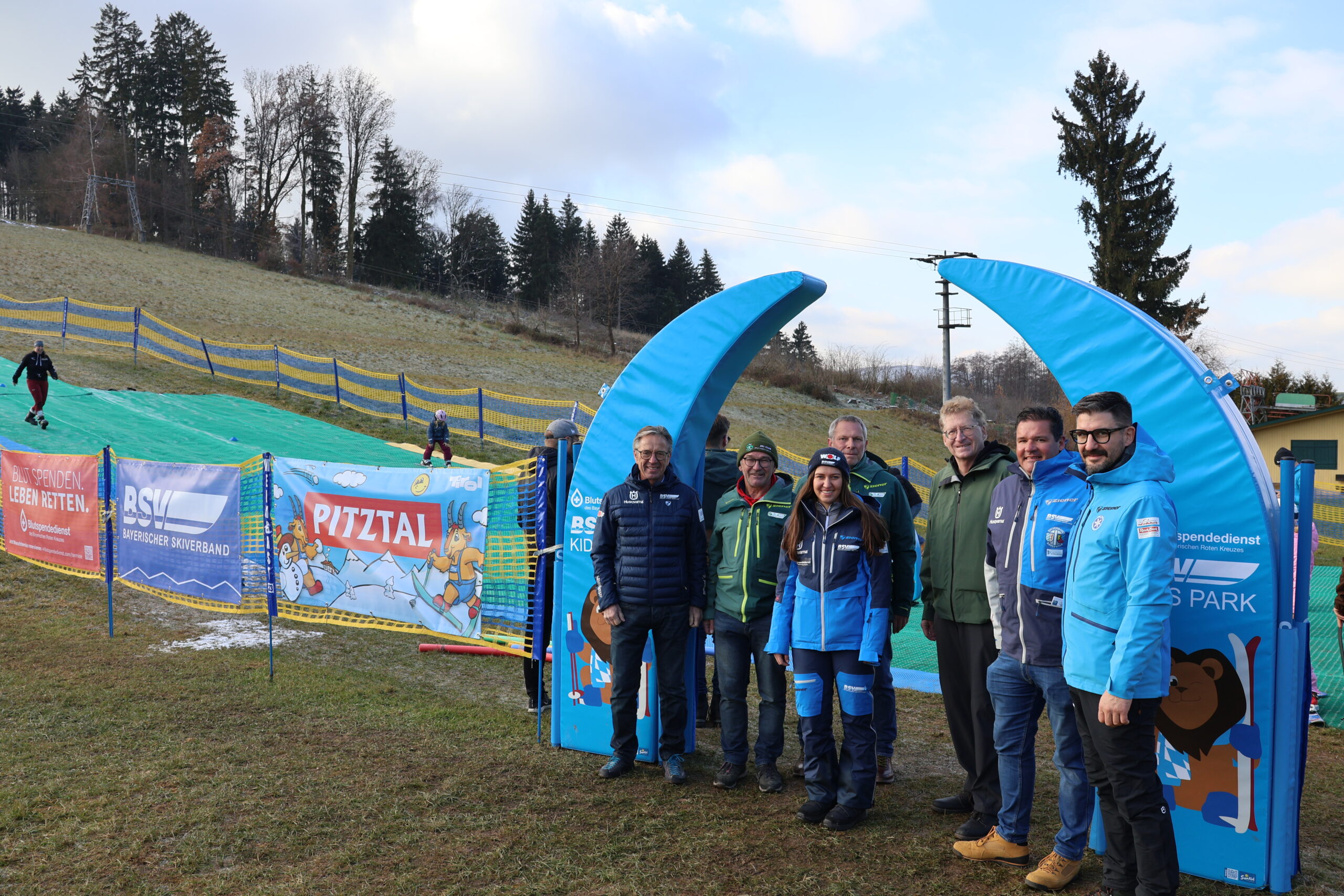 Gruppen von Menschen vor dem Torbogen des Mattenparks