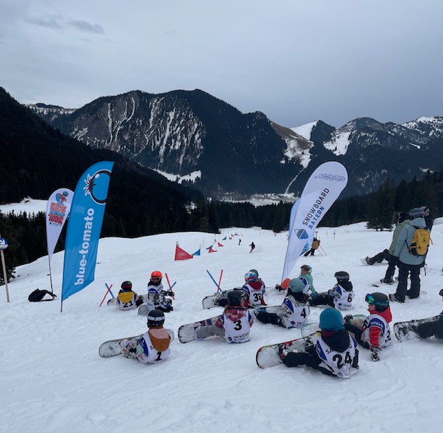 Gruppe Snowboarder sitzen im Schnee