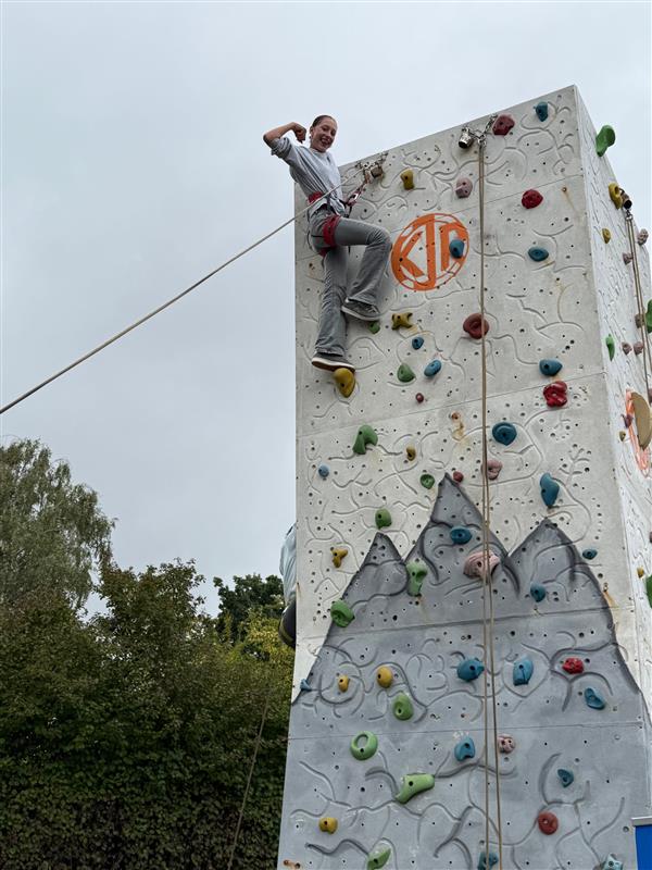 Person klettert an einem Kletterturm