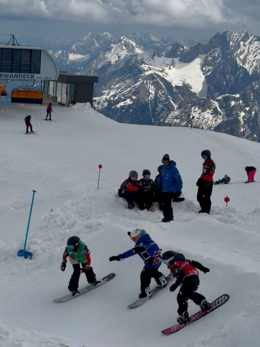 3 Snowboarder fahren nebeneinander ein Rennen