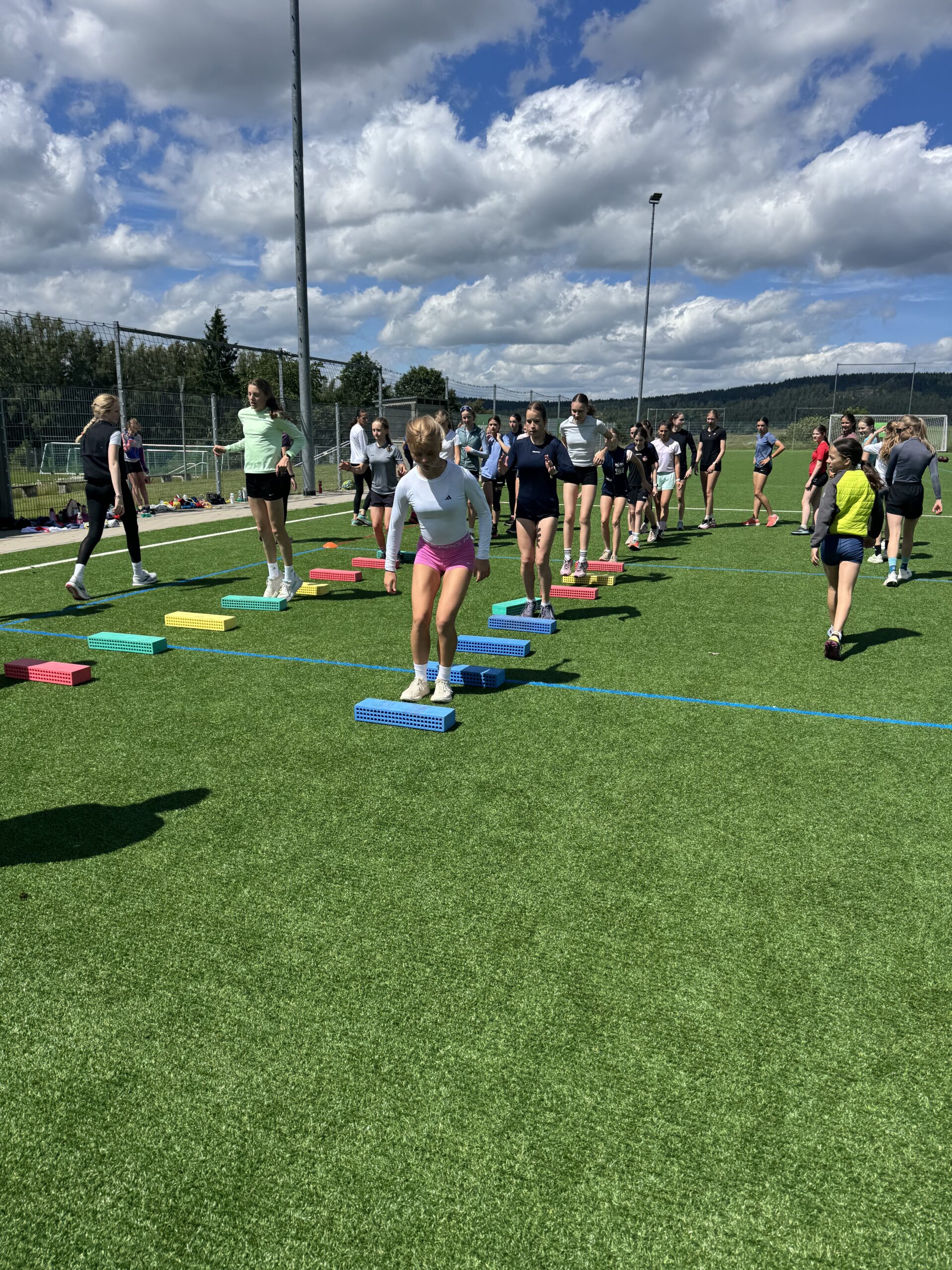 Sportler laufen Parcour auf Rasen