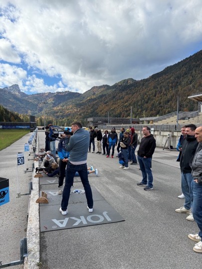 Personen stehen an einem Biathlon Skistand und probieren es aus.