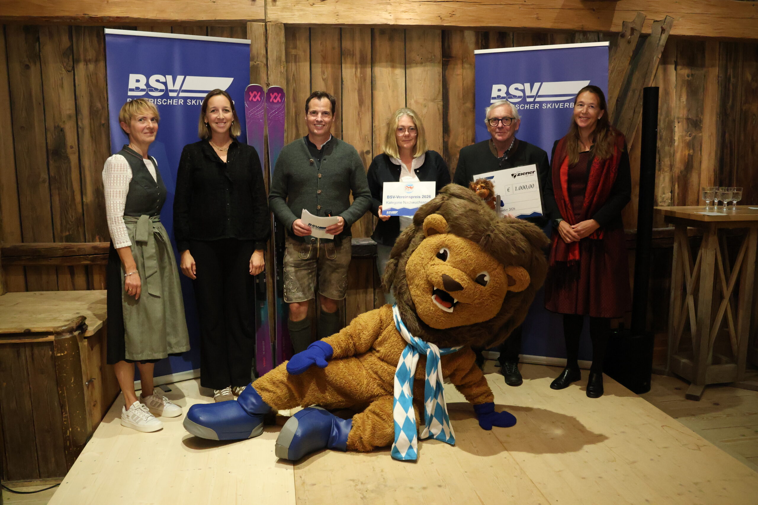Gruppenbild mit sechs Personen und einem Maskottchen bei Preisübergabe
