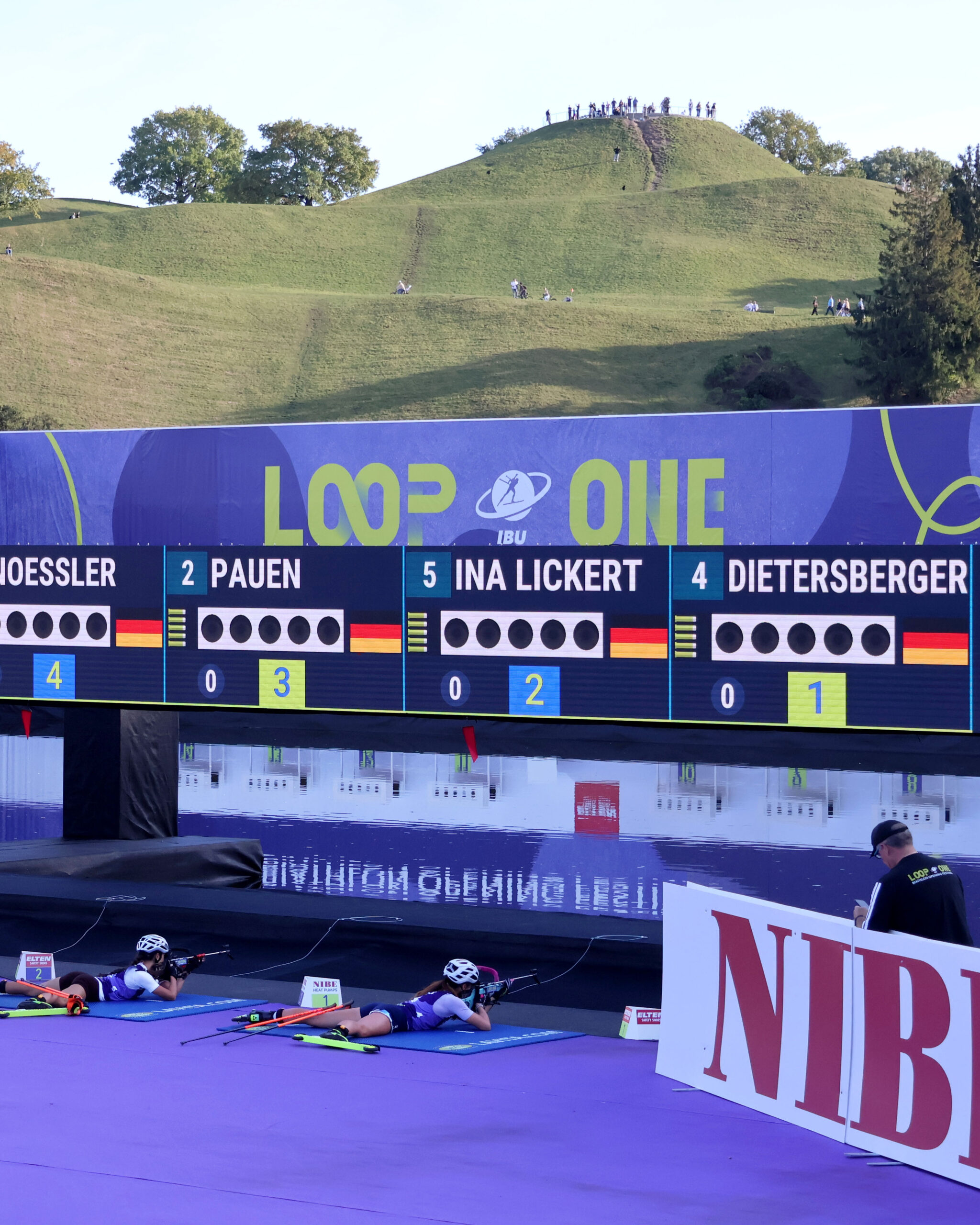 2 Mädchen beim liegenden Schießen mit dem Olympiaberg im Hintergrund