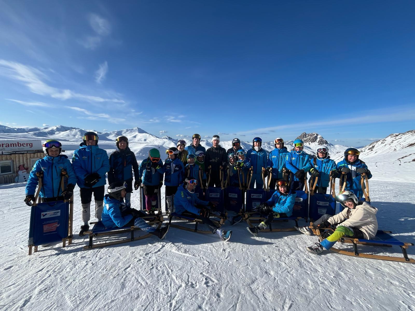 Gruppenbild im Schnee mit Holzschlitten