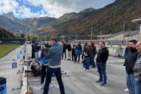 Personen stehen an einem Biathlon Skistand und probieren es aus.