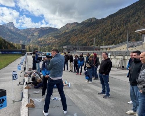 Personen stehen an einem Biathlon Skistand und probieren es aus.