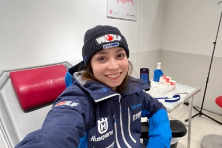 Frau auf Krankenliege mit Skiklamotten beim Blutspenden