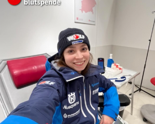 Frau auf Krankenliege mit Skiklamotten beim Blutspenden