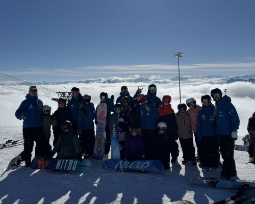 Gruppenfoto von Snowboardern &uuml;ber dne Wolken