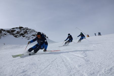 3 skifahrer fahren hintereinander auf der piste